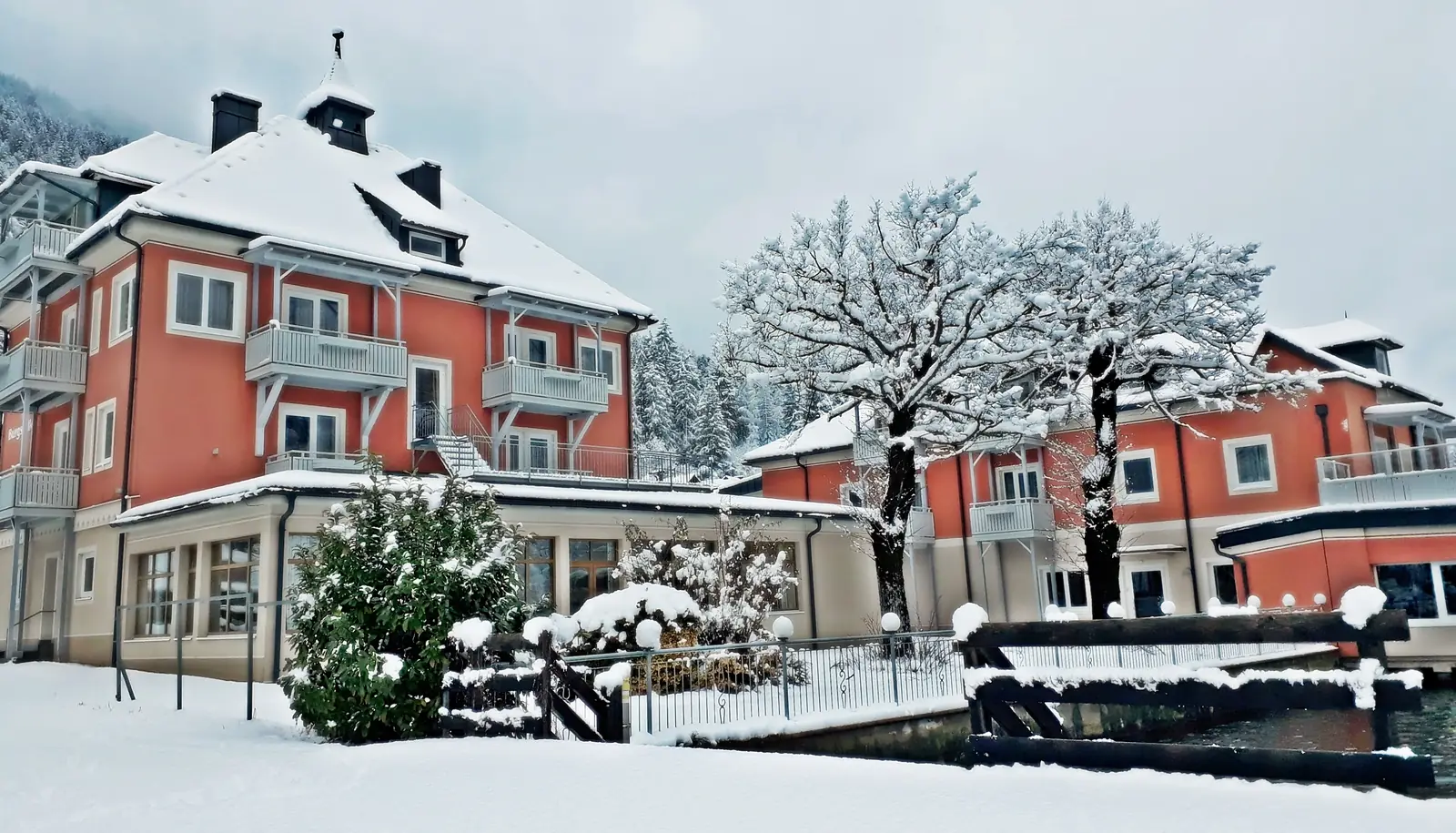 Strandhotel Burgstaller in winter - snow-covered facade on Lake Brennsee