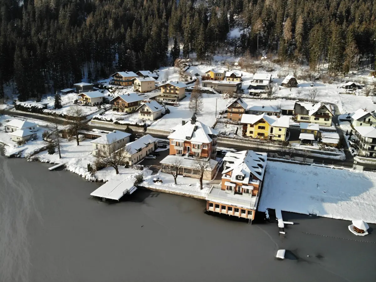 Das Strandhotel und Feld am See im Schnee von oben